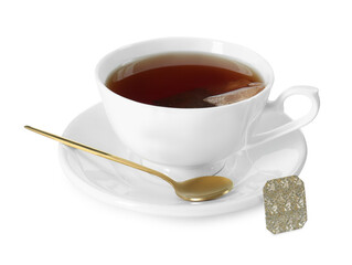 Brewing aromatic tea. Cup with teabag and golden spoon isolated on white