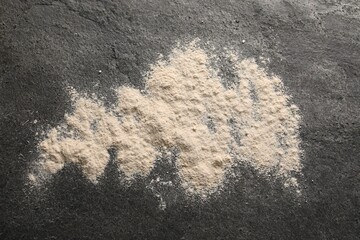Scattered flour on grey textured table, top view
