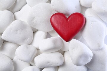 Obraz premium Decorative heart on white pebble stones, top view