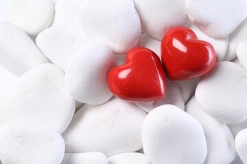 Obraz premium Decorative hearts on white pebble stones, top view