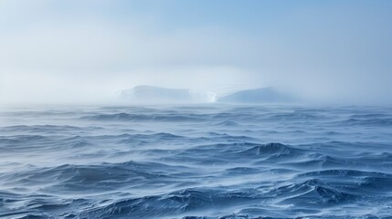 Obraz premium A vast expanse of water, dotted with distant icebergs, on a fog-shrouded day in the heart of the ocean