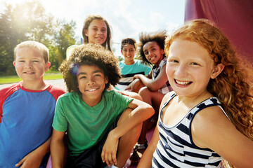 Kids, group and portrait on playground in park to relax with friends in summer on vacation. Happy, holiday and children together for camp, games or smile outdoor at middle school recess or break