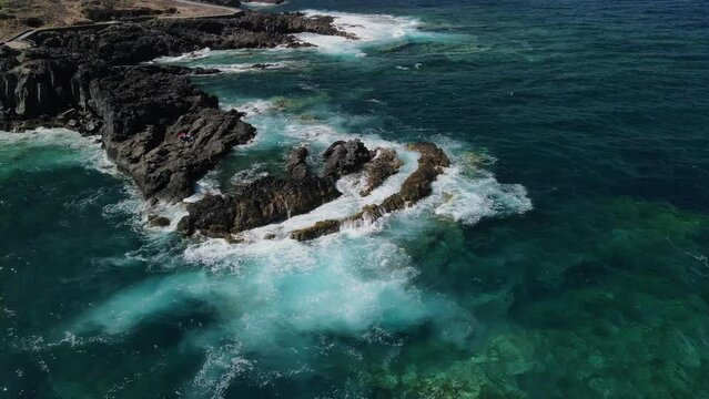 Fly over playa de rojas beach across rough coast with splashing waves