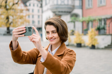 Woman taking a photo with mobile while visiting a city