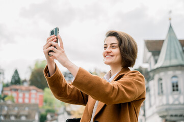 Smiling woman taking a photo of a beauty old town