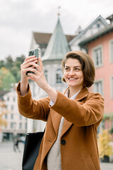 Woman taking selfie while visiting the downtown of a city