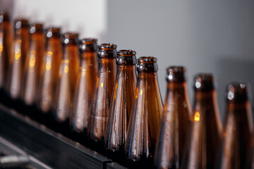 Glass bottles of beer on dark background. Concept banner brewery plant production line