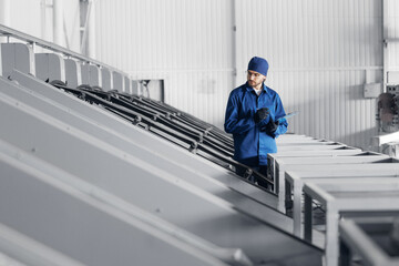 Worker engineer checks bearings on conveyor belt. Concept control quality product on modern food...