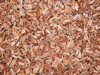 Wood chips texture/background: versatile material for playgrounds, landscaping, fuel, and wood processing industries, contributing to sustainability.