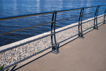 Strong metal railings on embankment