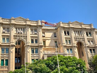 view of the facade of an old stone building in Malta with historic architecture with columns on a sunny summer day
