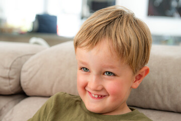 portrait d'un petit garçon souriant, regardant la télévision