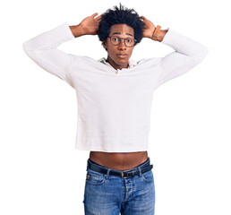 Handsome african american man with afro hair wearing casual clothes and glasses doing bunny ears...