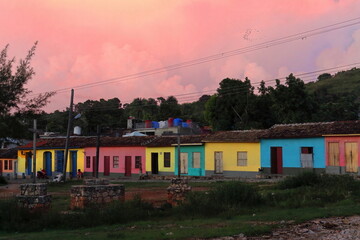 INCIDENTAL, NON RECOGNIZABLE PEOPLE IN THE IMAGE. Pastel-colored, one-story modest houses in a line...