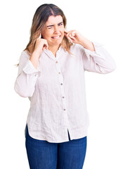 Fototapeta premium Young caucasian woman wearing casual clothes covering ears with fingers with annoyed expression for the noise of loud music. deaf concept.