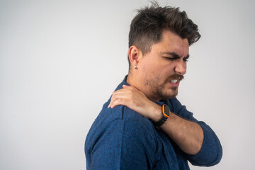 Shoulder pain. Man with arm injury indoor. Healthcare and medicine concept. People, healthcare and problem concept - unhappy man suffering from neck or shoulder pain at home