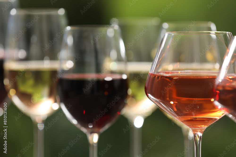 Poster Different tasty wines in glasses against blurred background, closeup