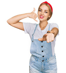 Young caucasian girl wearing casual clothes smiling doing talking on the telephone gesture and...