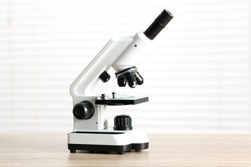Modern medical microscope on wooden table indoors