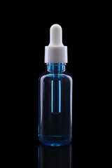 One blue bottle with tincture on mirror surface against black background