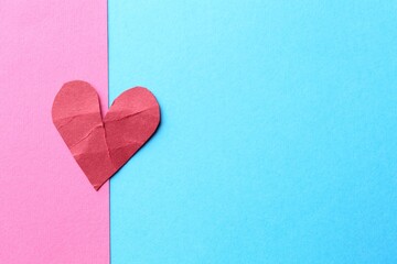 Red crumpled paper heart on color background, top view and space for text. Breakup concept