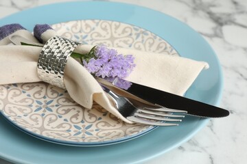 Stylish setting with cutlery and plates on white marble table, closeup