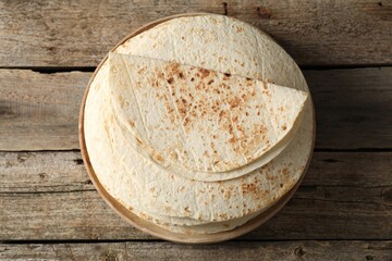 Stack of tasty homemade tortillas on wooden table, top view