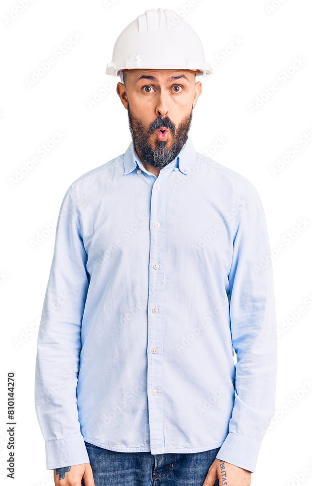 Wall mural Young handsome man wearing architect hardhat afraid and shocked with surprise expression, fear and excited face.