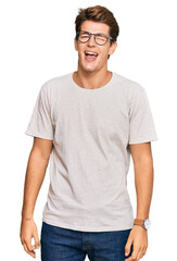Obraz premium Handsome caucasian man wearing casual clothes and glasses winking looking at the camera with sexy expression, cheerful and happy face.
