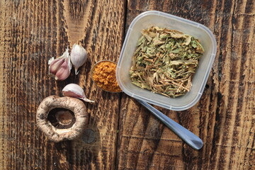 Garlic Dried herbs and champignon on the vintage wooden background, top view