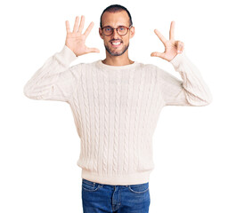 Young handsome man wearing casual clothes and glasses showing and pointing up with fingers number eight while smiling confident and happy.