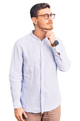 Handsome young man with bear wearing elegant business shirt and glasses touching painful neck, sore throat for flu, clod and infection