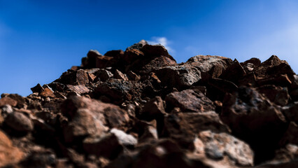 Pile of stones with blue sky background, close-up.