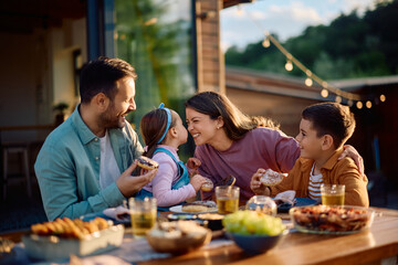 Cheerful family enjoying in meal on meal patio.