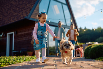 Little girl enjoying with her dog in backyard.