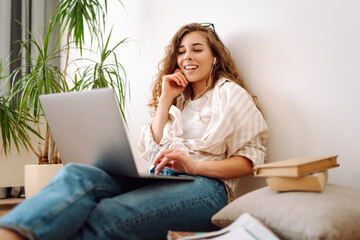 Young  IT woman use work on laptop  stay at home, hotel, spend free spare time in living room indoor. Lifestyle lounge concept. Freelance, online course.