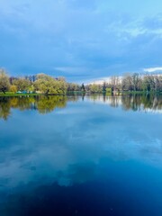 Obraz premium Pond in the park, evening time, trees reflection on the water surface