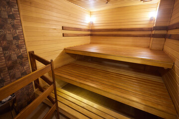 A hardwood sauna with a plank ceiling, brick wall, and stairs