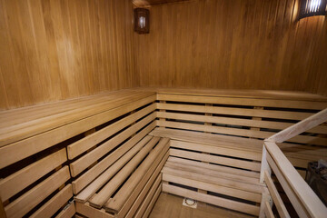 A hardwood sauna with a plank ceiling, brick wall, and stairs