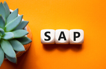 SAP - Systems Applications Products. Wooden cubes with word SAP. Beautiful orange background with...