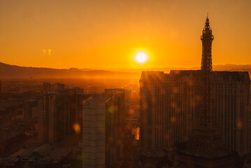 Breathtaking view of Las Vegas Strip at sunset, golden hues light up cityscape with Eiffel Tower...