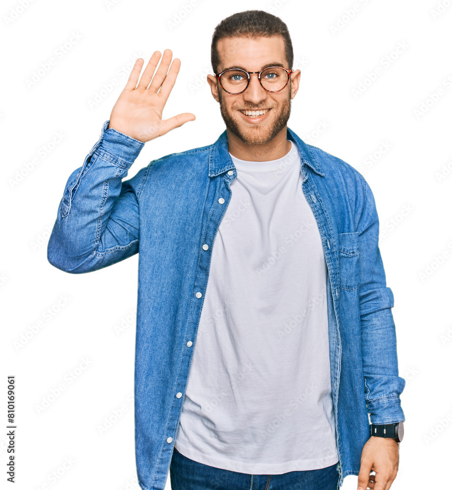 Sticker young caucasian man wearing casual clothes waiving saying hello happy and smiling, friendly welcome 