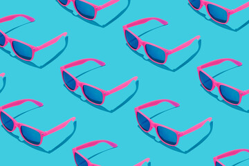 Pink sunglasses pattern on pastel blue background. Minimal summer concept.