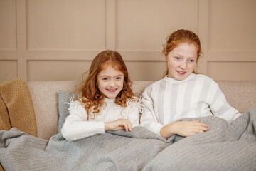 Sisters Enjoying Cozy Time on Couch. Children.