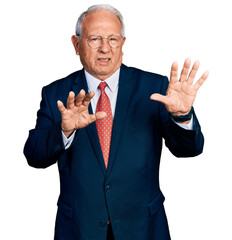 Senior man with grey hair wearing business suit and glasses moving away hands palms showing refusal...