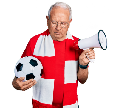 Senior man with grey hair football hooligan holding ball and using megaphone depressed and worry for distress, crying angry and afraid. sad expression.