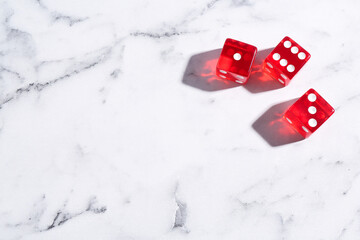 Three red game dices on white marble table, flat lay. Space for text
