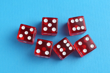 Many red game dices on light blue background, flat lay