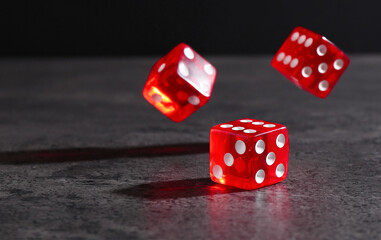 Many red game dices falling on grey textured table
