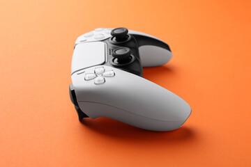 One wireless game controller on orange background